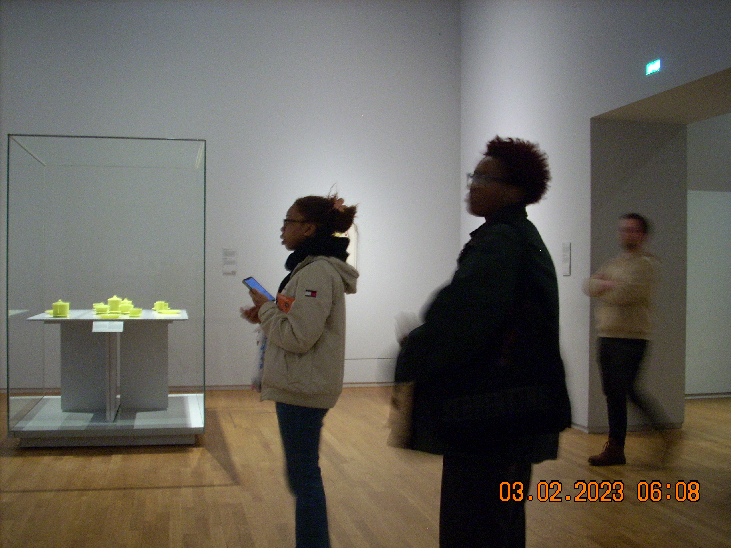two people standing facing left